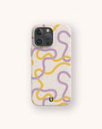 A smartphone with the Purple and Yellow Swirls Eco-Friendly Biodegradable Phone Case, featuring a playful pattern of wavy yellow and purple lines on a speckled beige background, is displayed against a light neutral surface.