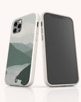 Two smartphones in light-colored cases, one revealing the screen and the other featuring the Blue Watercolour Landscape Eco-Friendly Phone Case, which displays a minimalist mountain landscape in muted green and gray tones on the back. Each device is protected by this eco-friendly phone case, combining style with sustainability.