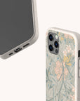Two smartphones with Jasmine Eco-Friendly Phone Cases in light colors: one facedown showing floral motifs, the other faceup displaying the screen as well as the case’s accessible ports and buttons.