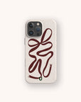 The Brown Bow Ribbon Eco-Friendly Phone Case in beige features an abstract, winding maroon ribbon resembling a snake with a small green mouth on a plain, light background, highlighting its sustainable design.