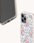 Two smartphones in floral cases are showcased. One highlights the back of the Pink and Blue Coquette Flowers Eco-Friendly Biodegradable Phone Case, decorated with delicate blooms and blue ribbons, while the other displays its screen and bottom edge, showing the charging port and speaker. This sustainable phone case combines style with eco-conscious design—ideal for those who value both beauty and responsibility.