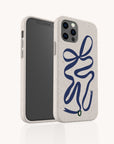 The Blue Bow Ribbon Eco-Friendly Phone Case features a speckled beige finish with a bold blue ribbon design. Compatible with iPhone and Samsung Galaxy, the case is angled to display both the screen and camera.
