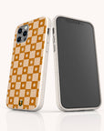 Two smartphones with beige eco-friendly phone cases: one is the Star Terracotta Checker Eco-Friendly Phone Case, featuring an orange and cream checkerboard with small white flowers and a green-orange accent; the other has a blank screen.