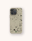 The Grunge Eco-Friendly Phone Case is a beige smartphone case with a black paint splatter design and a small green “U” at the bottom, displayed against a light background.