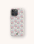 The Pink Coquette Flowers Eco-Friendly Biodegradable Phone Case, adorned with a vintage-inspired pink and purple floral pattern on a light background, is showcased against an off-white backdrop.