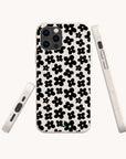 The Black Flower Power Eco-Friendly Phone Case in white showcases bold black floral patterns across the back, with views highlighting the phone case from the back, side, and bottom angles.