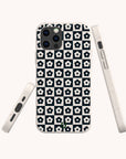 The Black Flower Checker Eco-Friendly Phone Case, made from biodegradable materials, displays white flowers on a black and white checkerboard pattern. The case is shown from the back and both sides on a plain light background.
