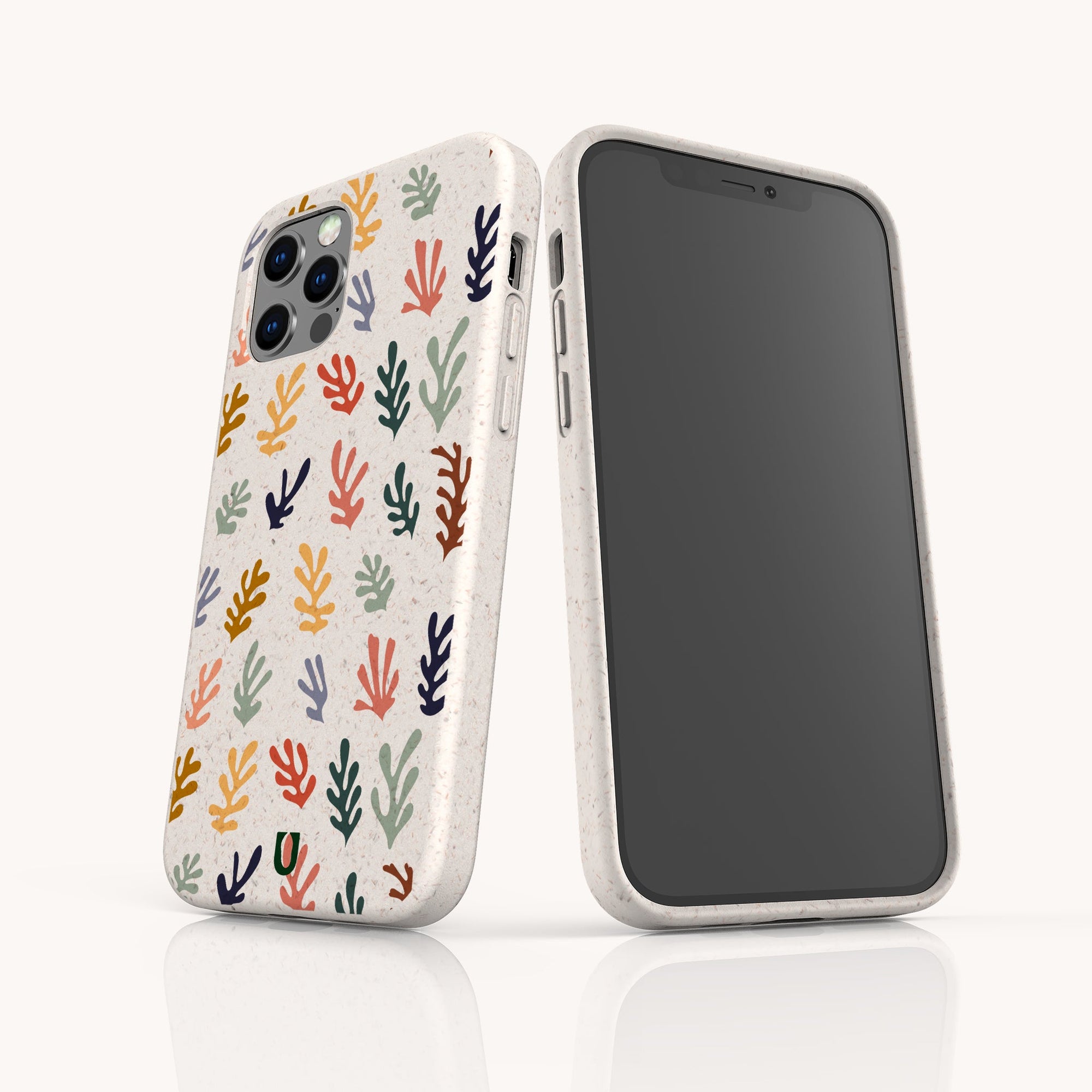 Two Algae Eco-Friendly Phone Cases in speckled white with colorful leaf patterns made from biodegradable materials. One phone displays the case’s design; the other shows its black screen, both on a white surface.
