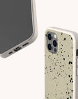 Two smartphones display the Grunge Eco-Friendly Phone Case in speckled beige and black. One phone shows the front screen, while the other highlights its urban-inspired splatter design, camera cutouts, and durable lightweight build.