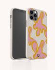 The Pink Abstract Flowers Eco-Friendly Phone Case is made from biodegradable, climate-positive materials and features pink and yellow abstract flower designs on a speckled beige background, shown covering a smartphone with dual camera lenses.