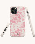 Three views of the Pink Roses Eco-Friendly Phone Case are shown against a white background, featuring a pink floral pattern. This phone case is made using eco-friendly materials, includes precise port cutouts, and displays a small horseshoe-shaped logo on the lower back.