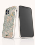 Two smartphones with white, speckled Jasmine Eco-Friendly Phone Cases are shown; one case features pastel floral motifs with green leaves, while the other faces forward with a plain black screen. Both stand upright on a white surface.