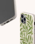 The Willow Eco-Friendly Phone Case features a beige background with a green leafy pattern, is plant-based, and is displayed front and back for iPhone and Samsung Galaxy, highlighting camera cutouts and side buttons.