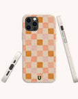 Three views of the Pink Watercolour Checker Eco-Friendly Phone Case, featuring a beige speckled finish with a pink and peach checkerboard pattern and small horseshoe logo. This zero-waste case combines stylish design with sustainability for iPhone and Samsung Galaxy.