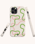 The Green and Pink Swirl Lines Eco-Friendly Phone Case features wavy green and pink lines on a speckled white background, is compatible with iPhone and Samsung Galaxy, and displays camera and button cutouts on the back and sides.
