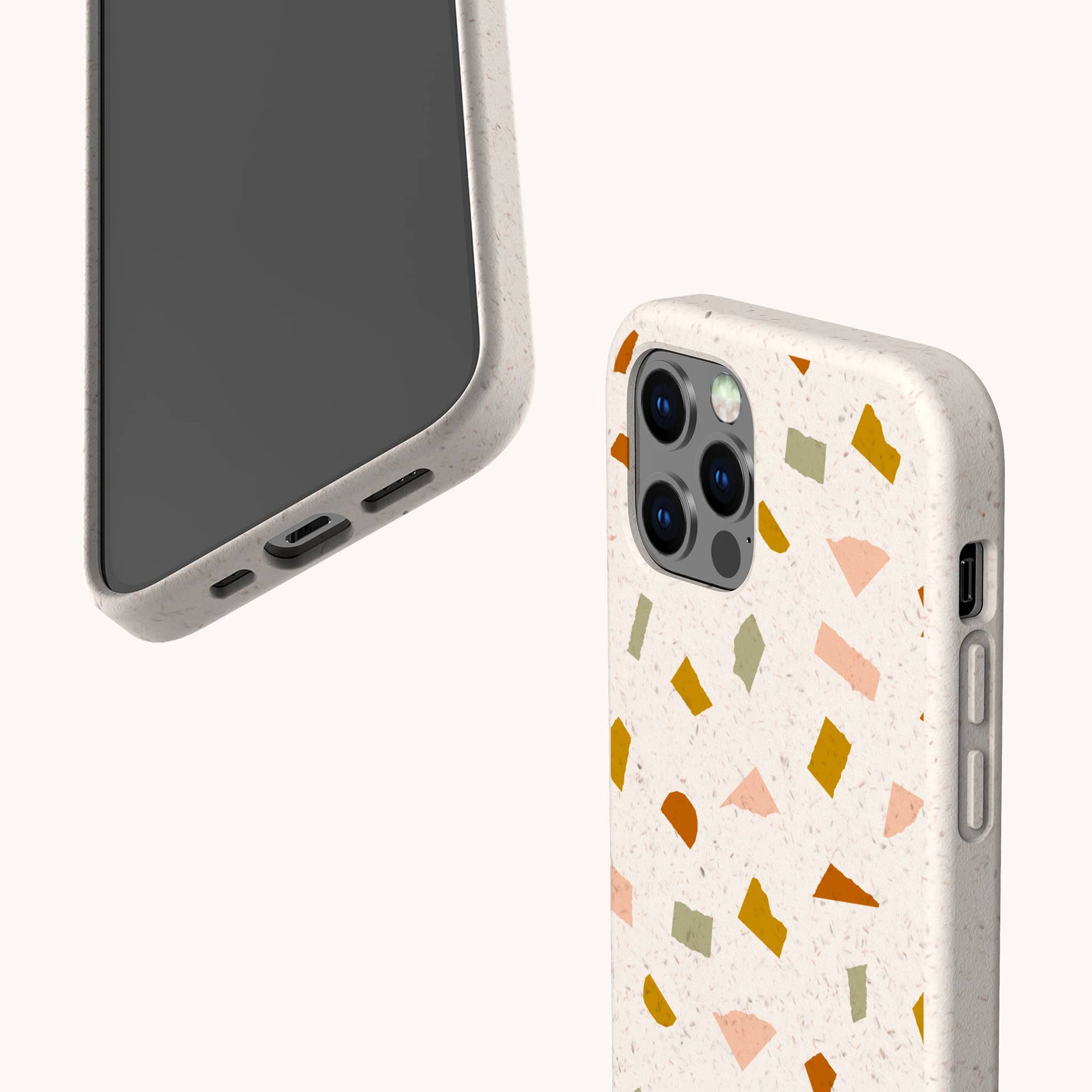 Two smartphones in beige Mini Confetti Eco-Friendly Phone Cases are shown; one shows the screen, the other features a colorful terrazzo pattern. These compostable cases fit iPhone and Samsung Galaxy models.