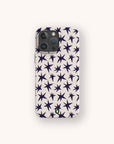 The Wonky Stars Biodegradable Phone Case is shown from the back, featuring a plant-based design with dark blue star patterns on a light beige background, centered on a plain off-white surface.