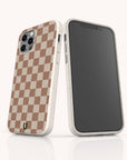 Two smartphones in white speckled cases; one displays its screen, the other shows the Almond Checker Eco-Friendly Phone Case with a brown and beige checkerboard pattern and green horseshoe logo—combining eco-conscious design and timeless style.