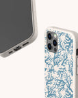 Two views of a smartphone in the Blue Coral Eco-Friendly Phone Case; one view highlights the screen and ports, while the other showcases the back with cameras and a striking blue and white coral pattern inspired by marine life.