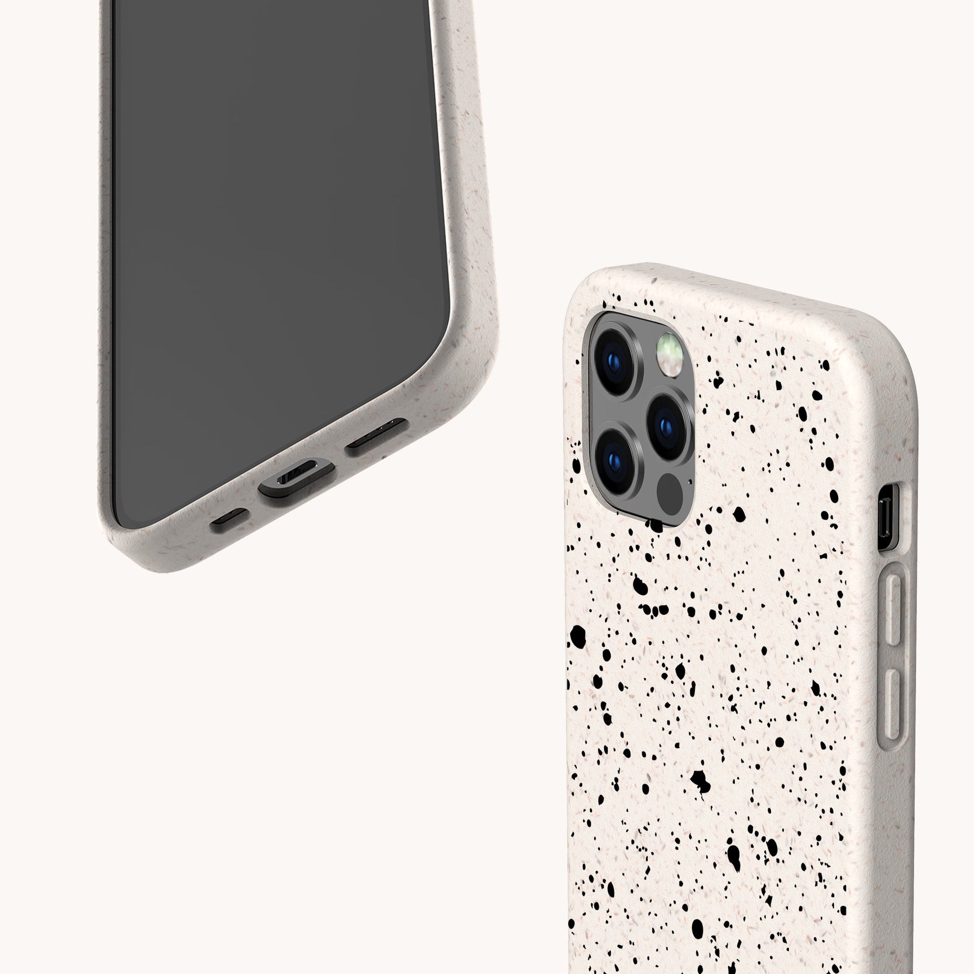 Two smartphones feature the Black Splatter Eco-Friendly Phone Case in off-white with a black paint splatter design; one displays the screen and the other the back. These compostable cases suit iPhone and Samsung. Minimal, light background.