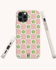 The Pink Flower Checker Eco-Friendly Phone Case features pink and white checks with bright green floral designs. Shown from back, side, and bottom on a light background. Compatible with iPhone and Samsung models.