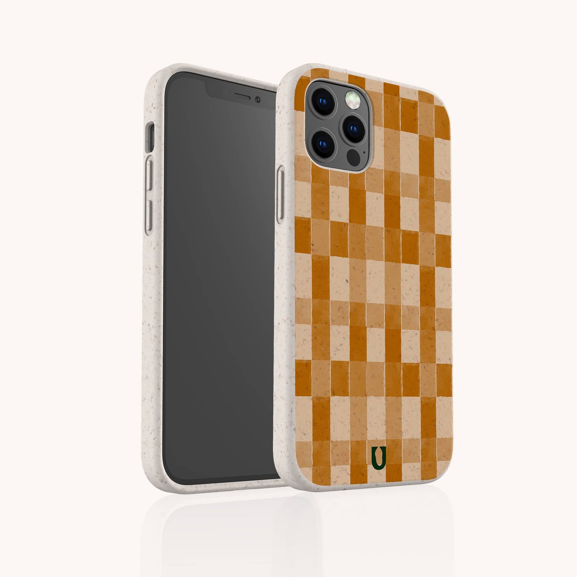 The Brown Watercolour Checker Eco-Friendly Phone Case, featuring a brown and beige checkerboard pattern, stands upright to showcase its sustainable style and camera-side design. Compatible with iPhone and Samsung models.
