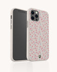 Two smartphones in floral pink and white cases with rose patterns, featuring the Pink Ditsy Flowers Eco-Friendly Biodegradable Phone Case—an attractive, sustainable option for eco-conscious buyers.