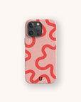 The Red and Pink Swirl Lines Eco-Friendly Phone Case is a biodegradable, pink phone case adorned with bold, wavy red lines and a small black “U” at the bottom center. Designed for both iPhone and Samsung devices, it features a light background for a stylish, eco-conscious look.