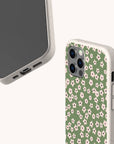 Two smartphones in beige cases: one plain, the other features the eco-friendly Vintage Green Flowers Phone Case with a green background and delicate white and pink flowers. Both are set against a light background.