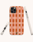 Three views of the Terracotta Watercolour Checker Eco-Friendly Phone Case, featuring a pink and orange checkerboard design, white border, and small horseshoe-shaped logo near the bottom center. Designed for sustainable impact.