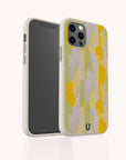 The Lime Sorbet Eco-Friendly Phone Case, in beige with a yellow, green, and lavender abstract brushstroke pattern, is displayed upright and slightly turned to reveal both the front and back.