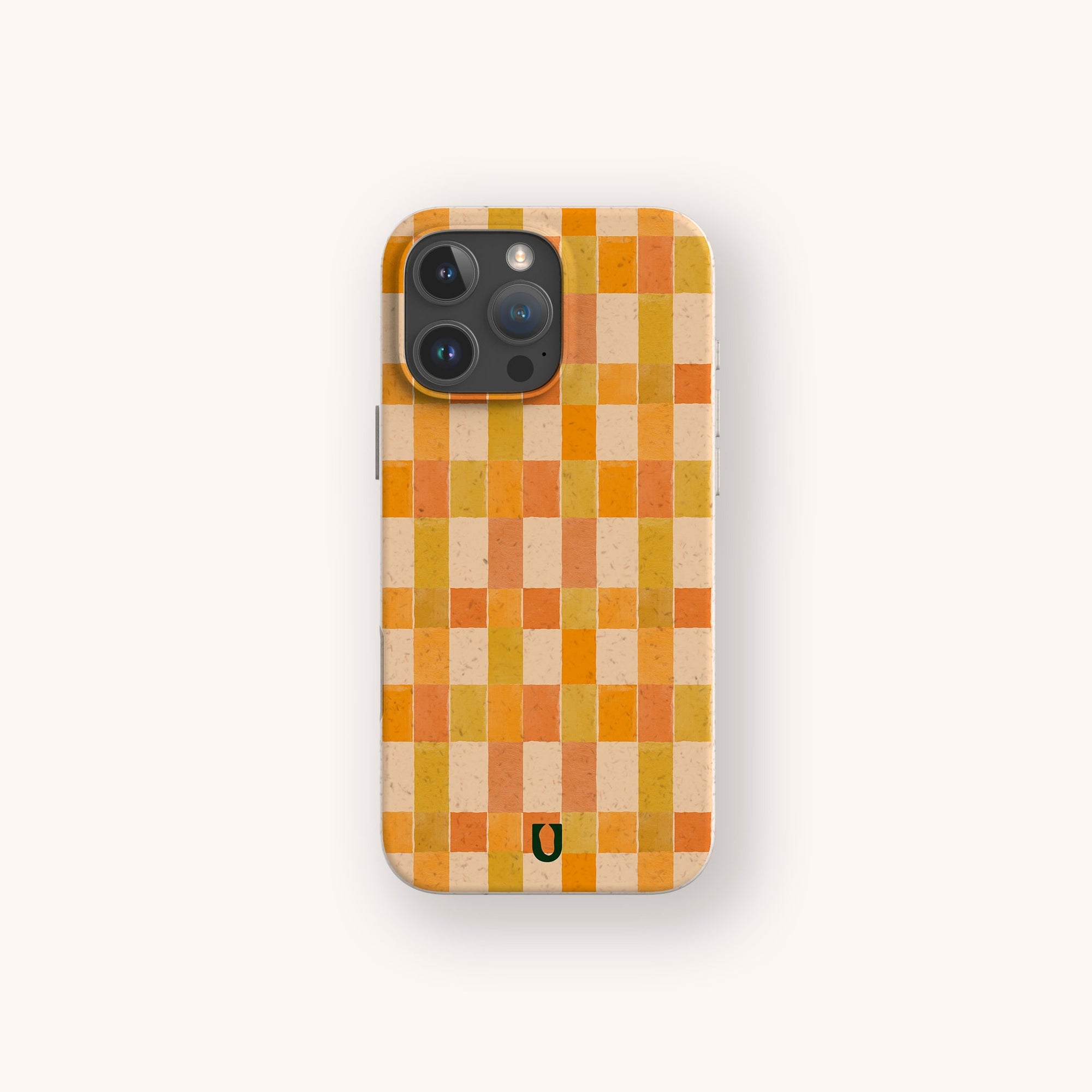 The Green and Orange Watercolour Checker Eco-Friendly Phone Case features a checkered pattern in orange, yellow, and beige with a small black horseshoe-shaped logo at the bottom, displayed against a light background.