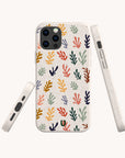 The Algae Eco-Friendly Phone Case features a vibrant abstract leaf or coral pattern in yellow, orange, red, purple, and green on a light speckled background. Made from biodegradable materials and displayed from several angles.
