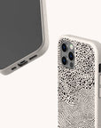 Two views of a smartphone with the Mini Strokes Eco-Friendly Biodegradable Phone Case in a light color. The back of this sustainable phone case displays an abstract black dot pattern, while the front reveals the phone’s screen and ports.