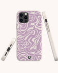 The Purple Marble Swirl Eco-Friendly Phone Case is shown from the back, side, and bottom angles. It features a light purple and white abstract wavy pattern with a minimalist design and a small logo near the bottom.
