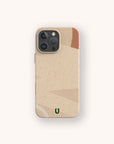 The Abstract Strokes Eco-Friendly Biodegradable Phone Case, shown on a beige iPhone, features a minimalist abstract design with a small green horseshoe logo at the bottom and is displayed against a light background.