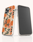 Two smartphones in beige cases stand upright on a white reflective surface. The phone case facing forward highlights the charm of the Orange Blossom Eco-Friendly Phone Case, featuring an orange blossom and leaf pattern. The other phone displays a blank black screen.