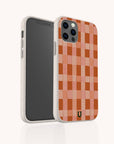 The Terracotta Watercolour Checker Eco-Friendly Phone Case, shown on a light background, features an orange and pink checkered pattern with rounded edges. Compatible with both iPhone and Samsung models, it is adorned with a small black horseshoe-shaped logo near the bottom.