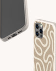 Two smartphones feature the Neutral Swirl Lines Eco-Friendly Phone Case in beige with speckled design. One shows the screen; the other displays a wavy, abstract white pattern and precise cutouts for ports and camera lenses.