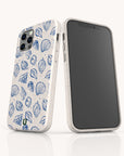 Two smartphones with the Sea Shells Eco-Friendly Phone Case, featuring blue seashell and leaf designs, showcase sustainable craftsmanship. One shows the back design; the other, compatible with iPhone and Samsung Galaxy, displays a blank black screen.