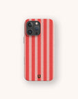 The Red and Pink Stripes Eco-Friendly Phone Case features bold vertical red and pink stripes with a small black horseshoe symbol near the bottom center, shown on a light background.