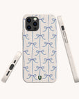 Introducing the Blue Bow Ribbons Eco-Friendly Biodegradable Phone Case: a delightful, sustainable accessory for your device featuring a crisp white background decorated with a repeating pattern of hand-drawn light blue bows. This compostable phone case is displayed from the back and two side angles, showcasing its precise button and port cutouts while providing both style and environmental responsibility.
