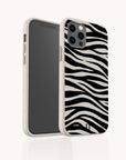 The Zebra Eco-Friendly Phone Case in beige features a black-and-white zebra stripe pattern, shown partly facing forward to highlight the rear design.