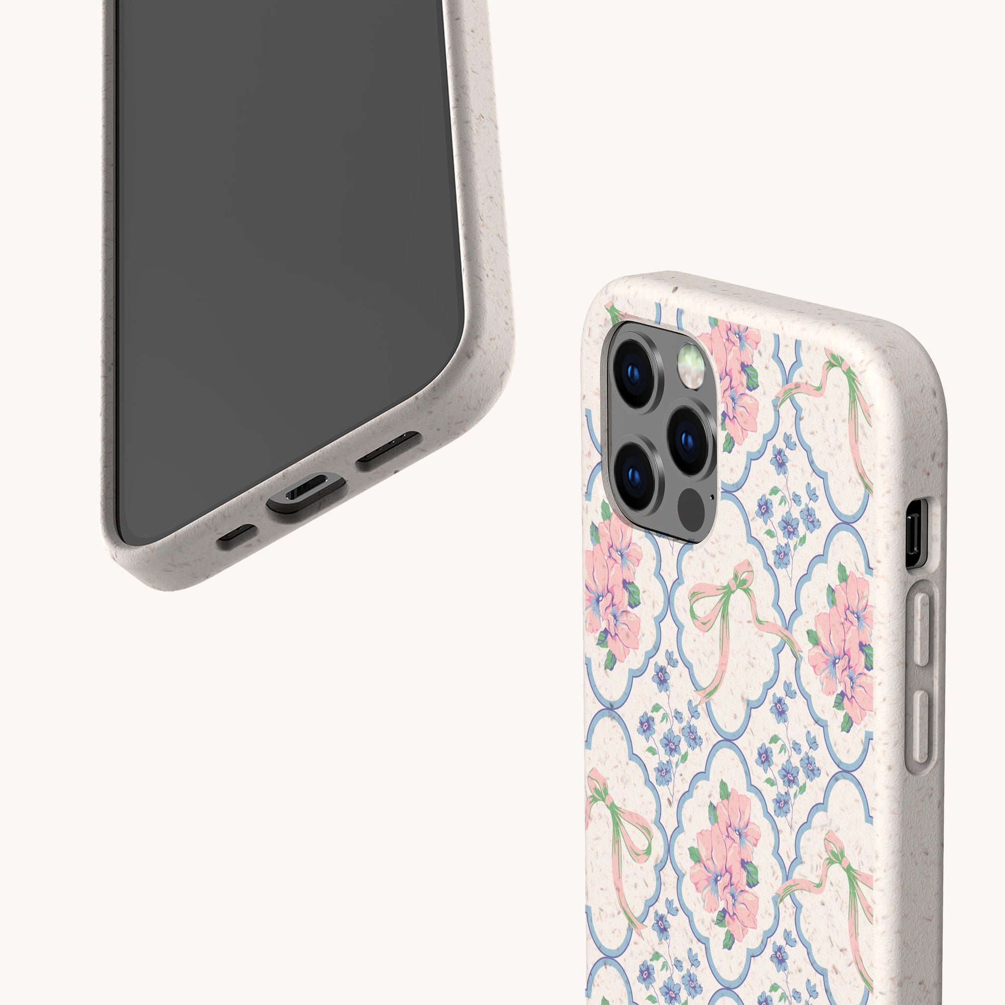 Two smartphones with pale beige Pink Ribbons Eco-Friendly Biodegradable Phone Cases: one features pink and purple flowers with green ribbons, while the other showcases a speckled, eco-friendly biodegradable texture.