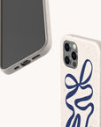 The Blue Bow Ribbon Eco-Friendly Phone Case features a speckled beige base with a blue abstract ribbon design, shown on a smartphone from front and back against a light background. Compatible with iPhone and Samsung Galaxy models.