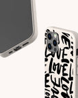 Two smartphones in white Love Words Eco-Friendly Biodegradable Phone Cases feature a bold, black handwritten “LOVE” text pattern. One phone displays its screen, while the other showcases the speckled-textured back and camera. Both eco-conscious cases combine stylish design with environmental responsibility.