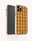 The Terracotta Watercolour Gingham Eco-Friendly Phone Case in beige features a stylish checkerboard pattern, shown standing upright to display its front screen and the sustainably designed patterned back.