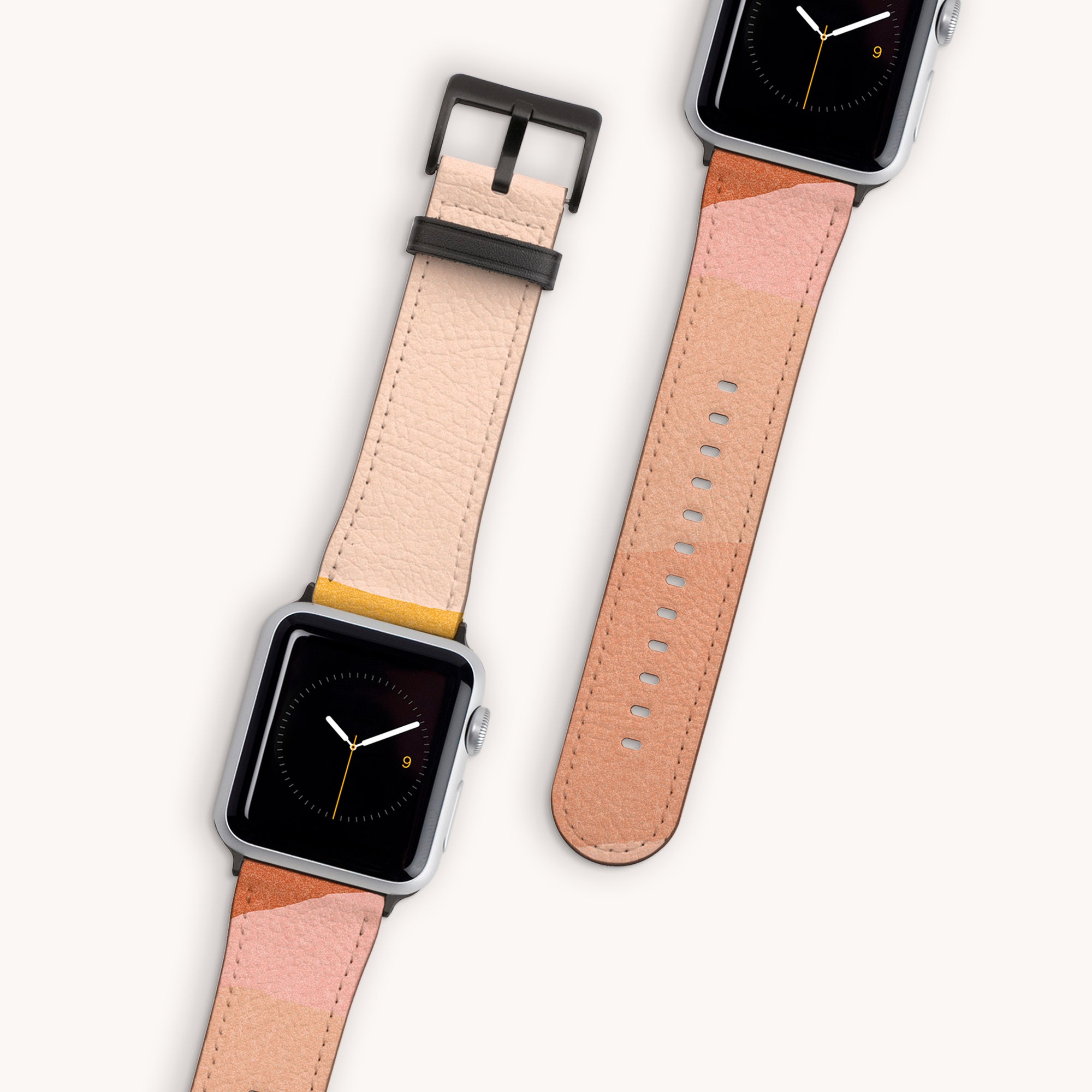 Two Abstract Cut Out Vegan Leather Apple Watch Bands with multi-toned straps in shades of pink and beige are displayed. Both feature a minimalist clock face with a black background and yellow and white hands. One watch band is detached, showcasing its elegant design.