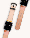 Two Abstract Cut Out Vegan Leather Apple Watch Bands with multi-toned straps in shades of pink and beige are displayed. Both feature a minimalist clock face with a black background and yellow and white hands. One watch band is detached, showcasing its elegant design.