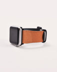 The Abstract Cut Out III Vegan Leather Apple Watch Band boasts a silver frame with a black screen and is paired with a brown vegan leather strap. This cruelty-free band features a smooth texture and is secured by a sleek black buckle, all elegantly displayed on a plain white background, emphasizing both sophistication and sustainability.
